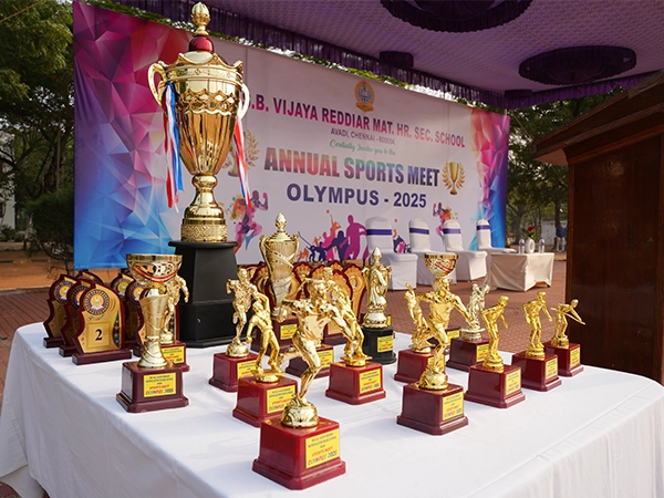 The winning team celebrating with their coach after receiving the championship trophy on Sports Day