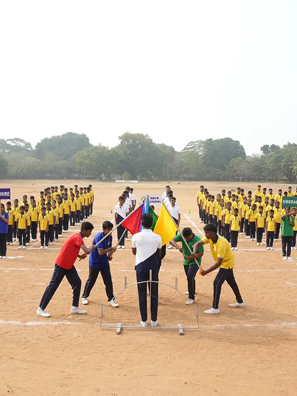 Strong Young athletes engaged in various sports activities on SBVR School's expansive sports ground.
